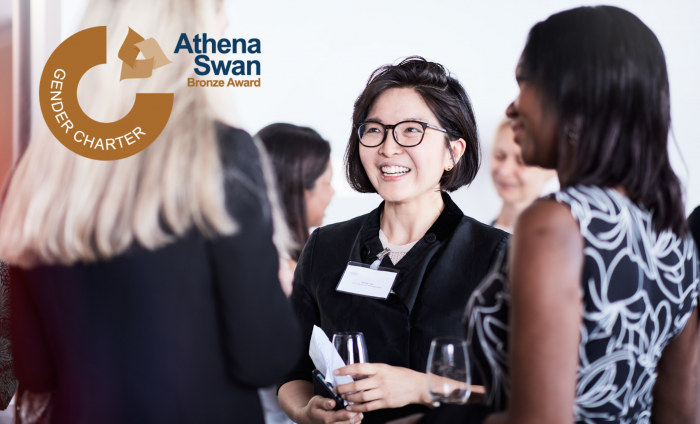 A group of women from the School of Management and the Athena Swan logo