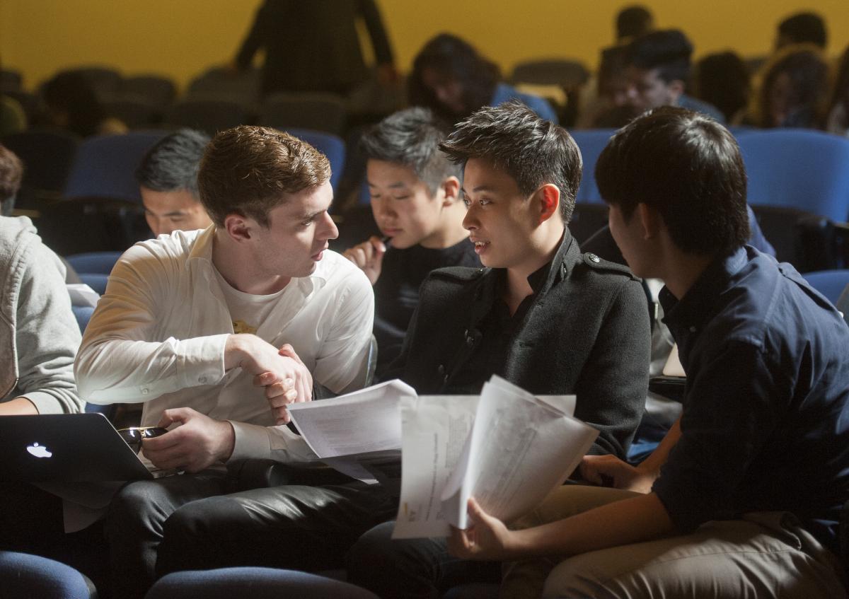 Two male students shake hands in a lecture